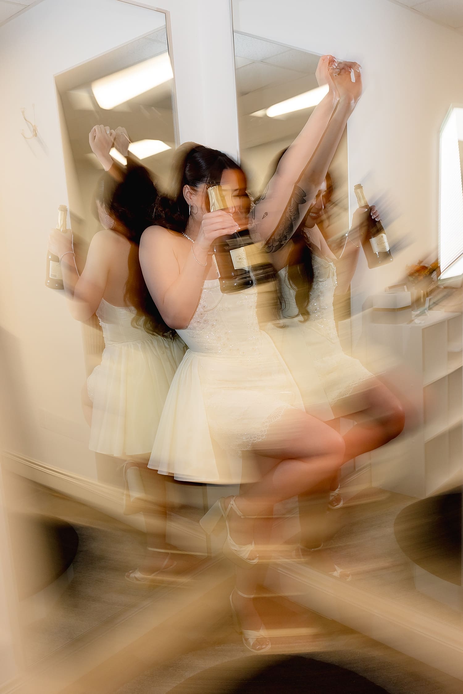 bride parties with a bottle of champagne in bridal suite by Southern California photographer
