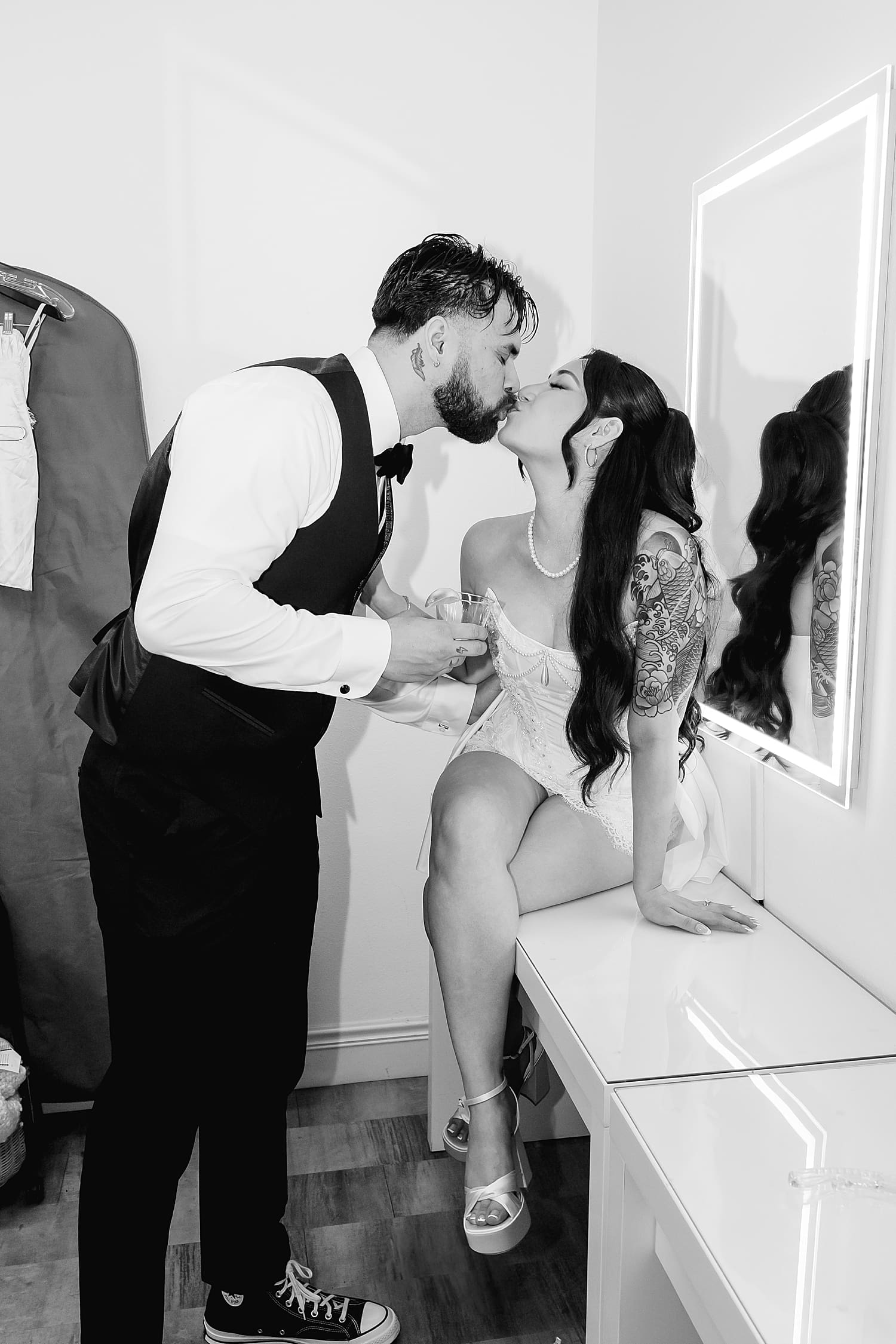 husband and wife steal a kiss in bridal suite by Desiree Ashley Photography