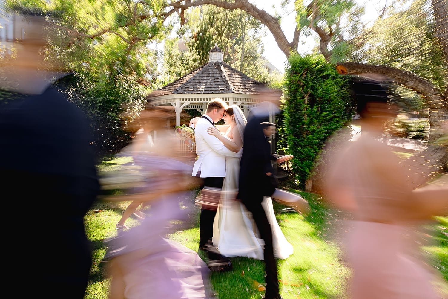 husband and wife stand on lawn at at University Club by Wedgewood Weddings with bridal party around