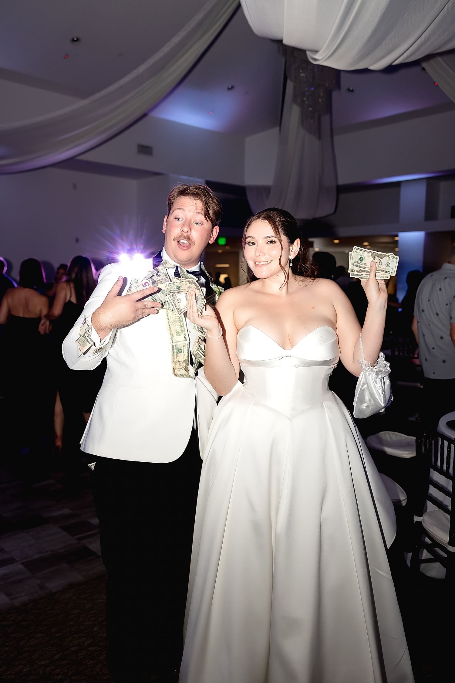 newlyweds hold up money from honeymoon dance at University Club
