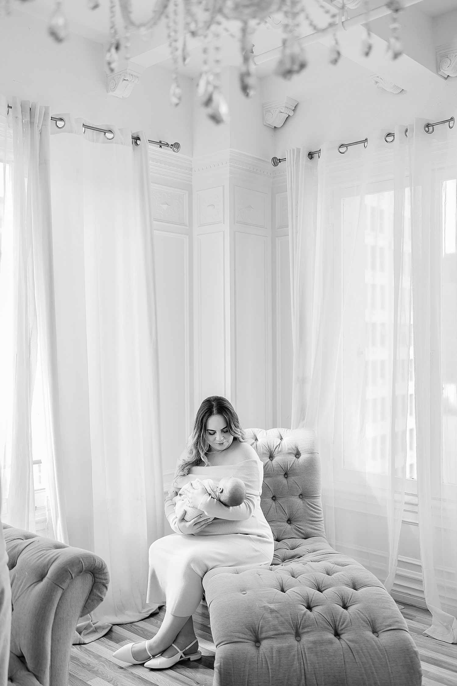 mother with infant sits on large lounger documenting their full love story