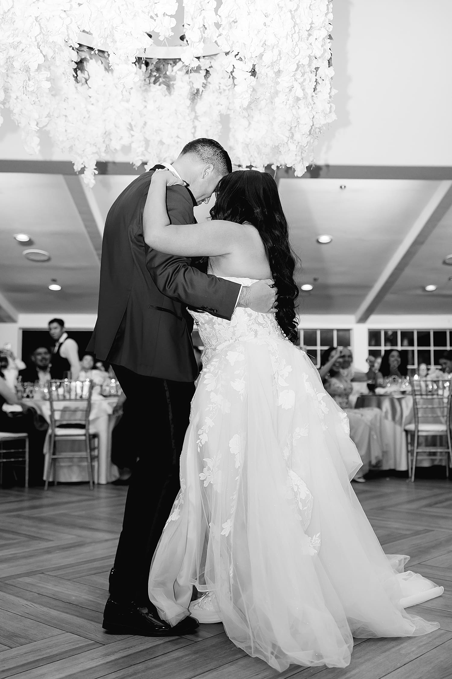 newly married couple dance closely under flowers at reception by Desiree Ashley Photography