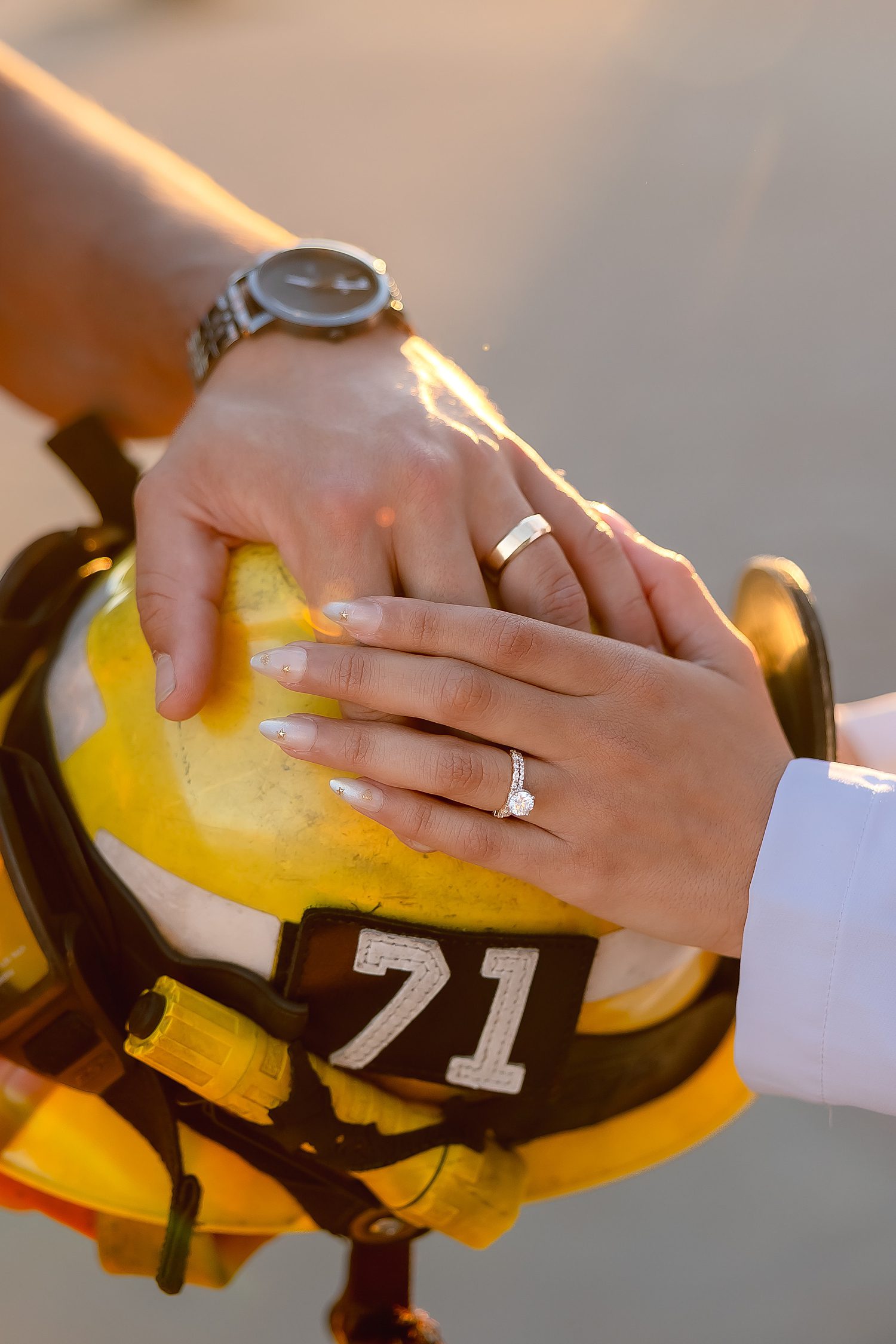 firefighter and DDS doctor place their hands on helmet for unique couples session idea