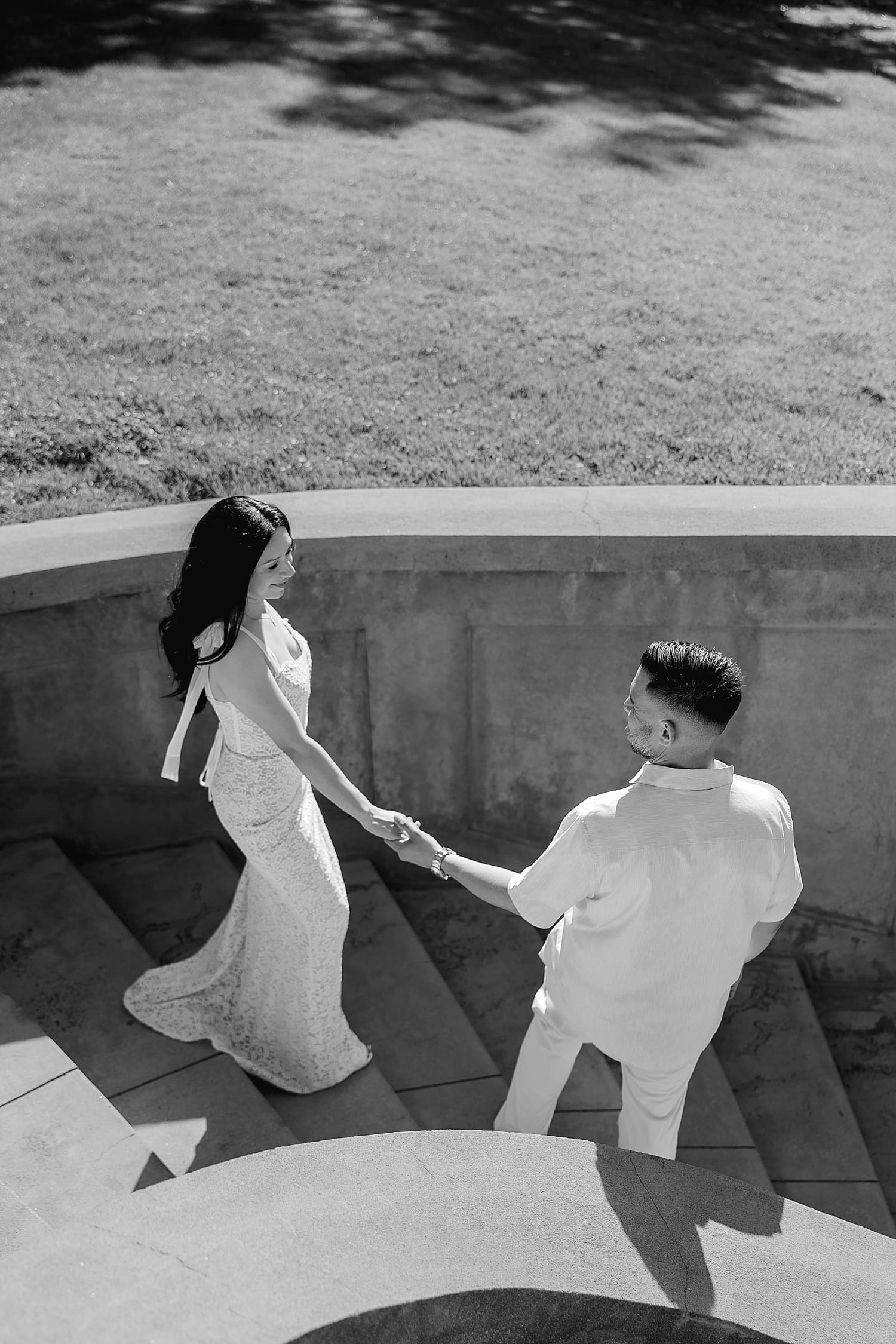 bride and groom to be walk down big stone steps by Desiree Ashley Photography