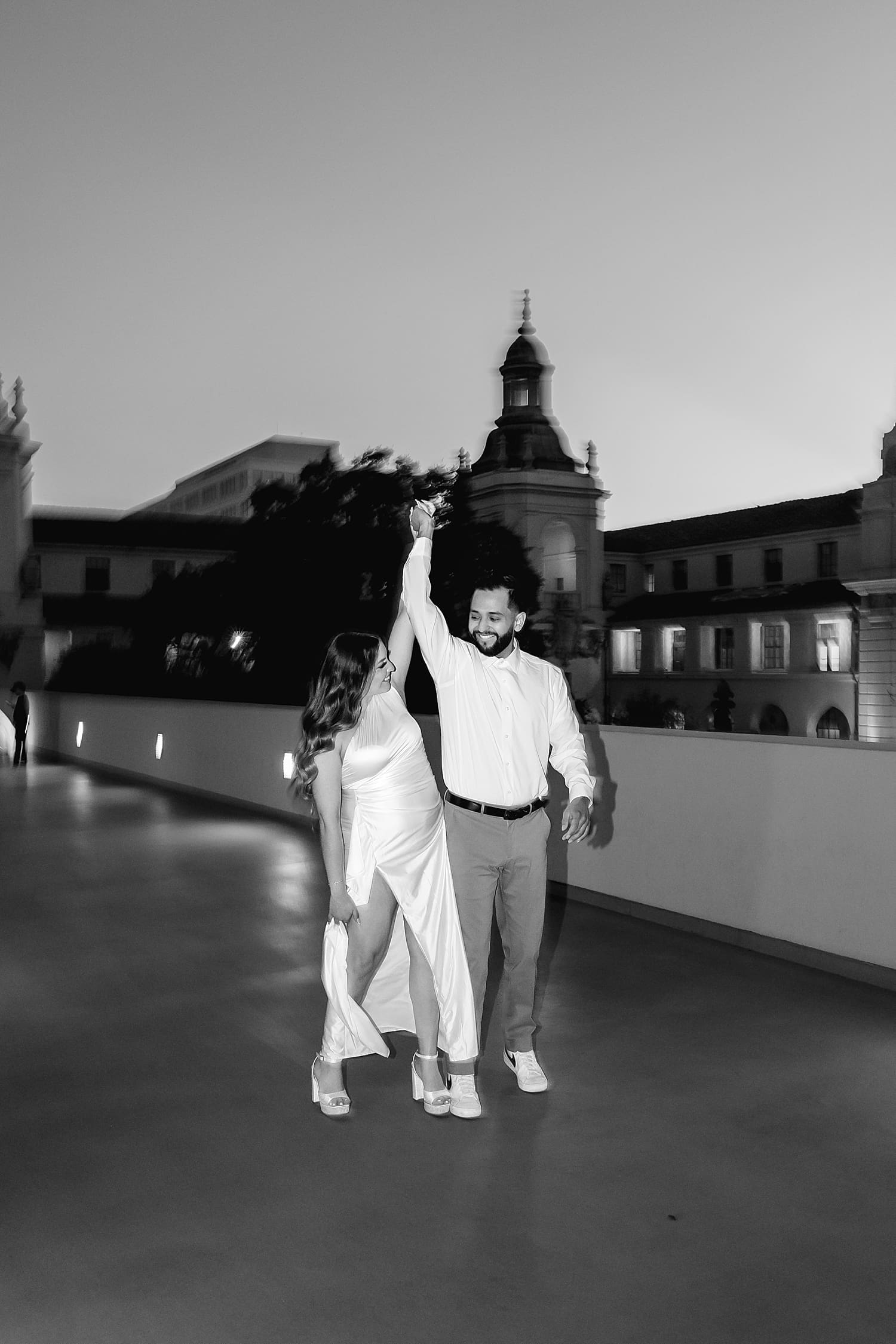 couple playfully walking on rainy rooftop by Southern California Wedding Photographer