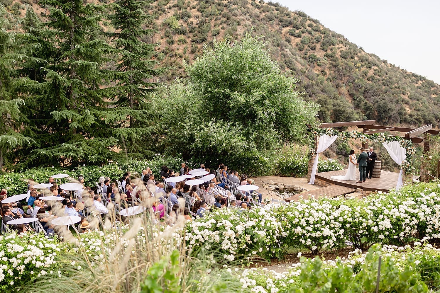 guests sit on lawn overlooking outdoor ceremony by Southern California wedding photographer