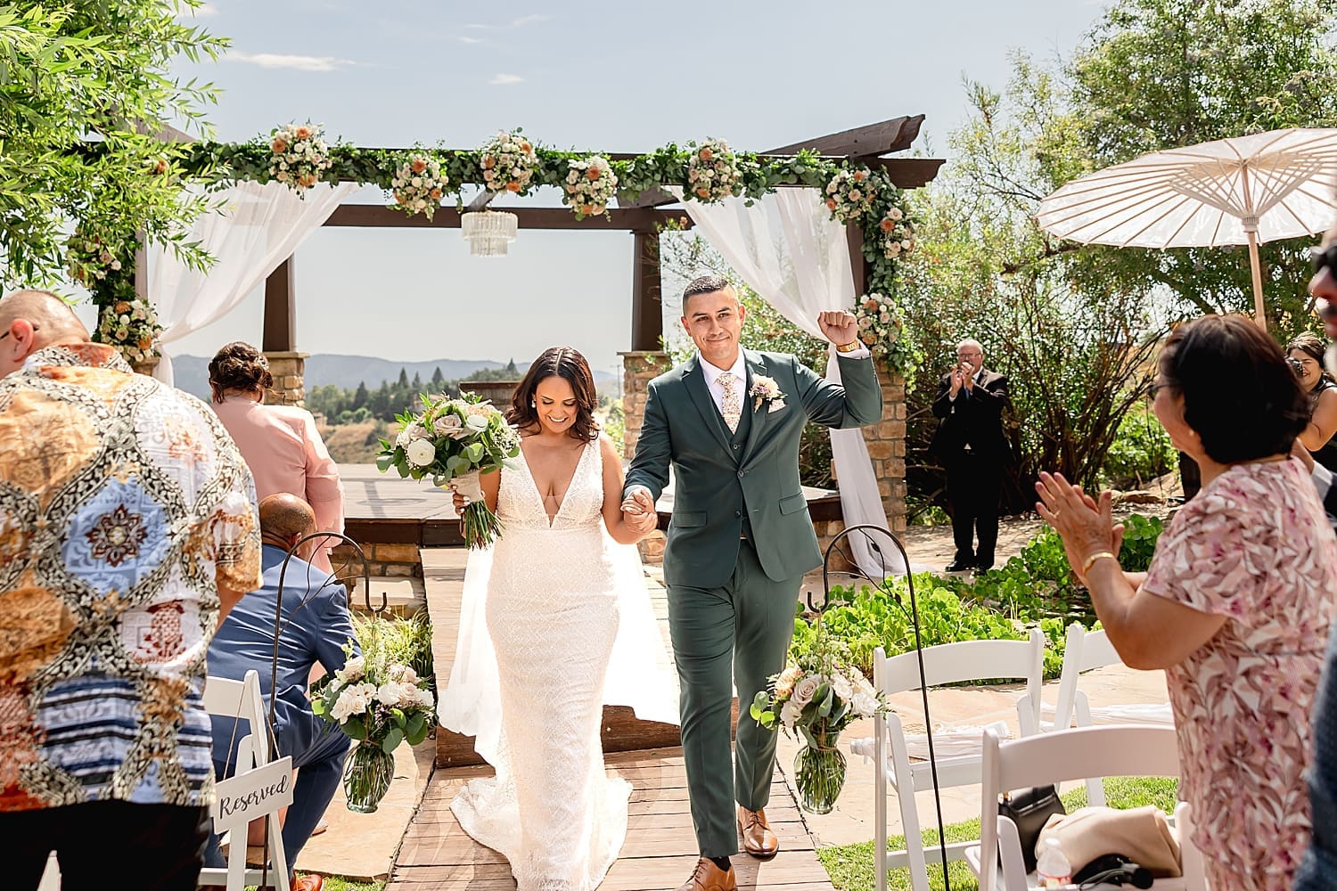 newlyweds fist pump the air in celebration after ceremony at Serendipity Gardens