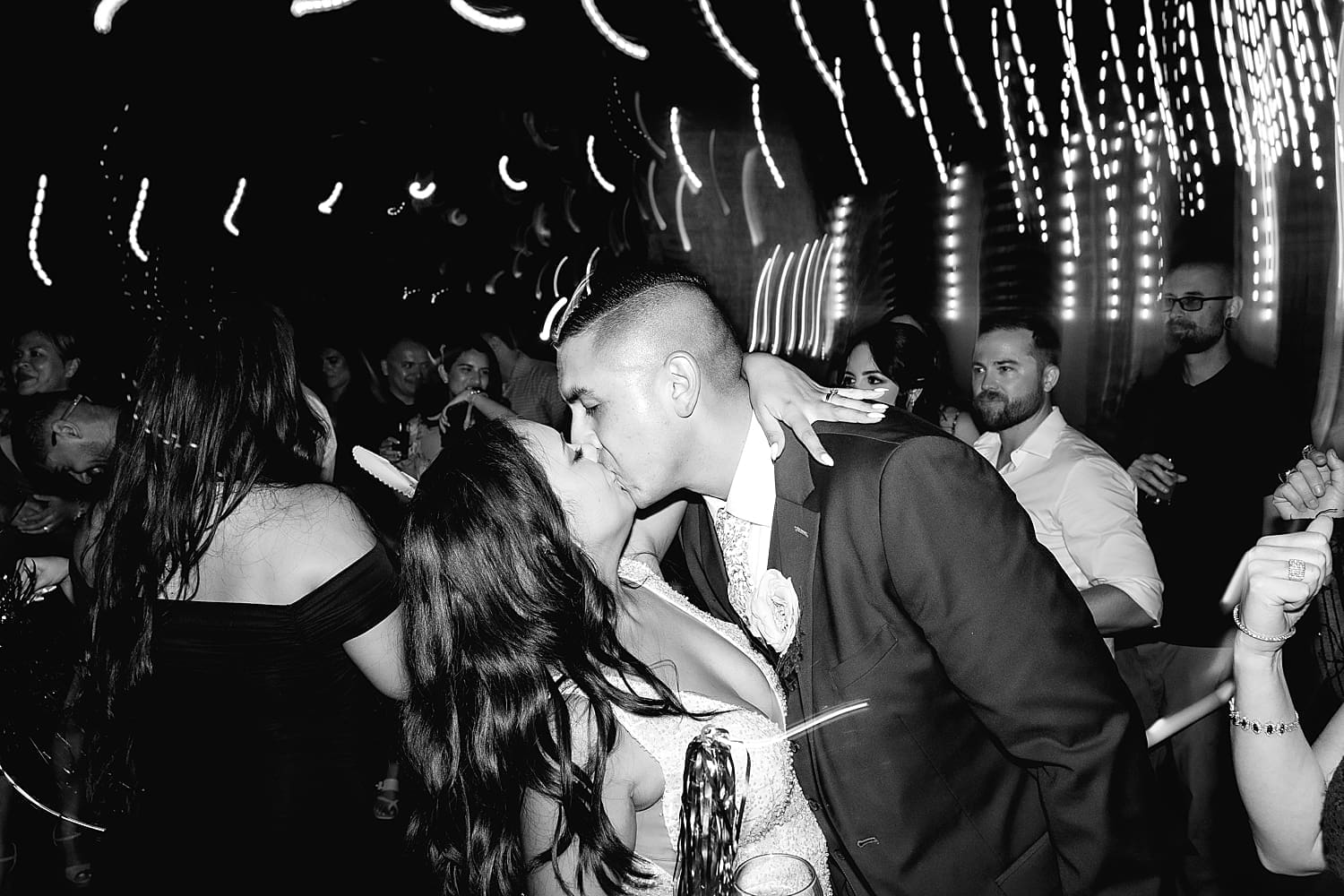 couple share a kiss on dance floor at end of reception by Desiree Ashley Photography