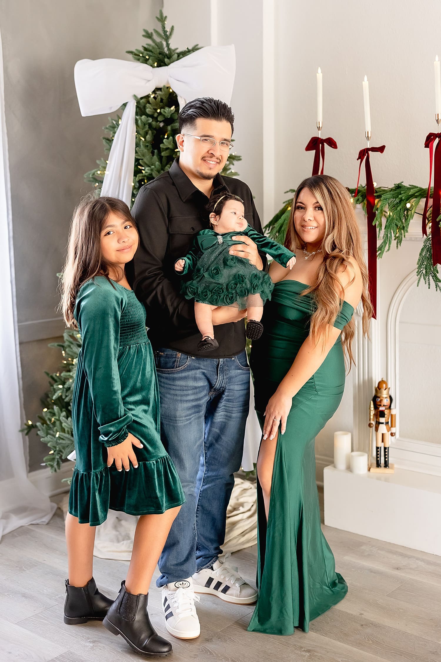family stands in front of christmas tree for holiday sessions