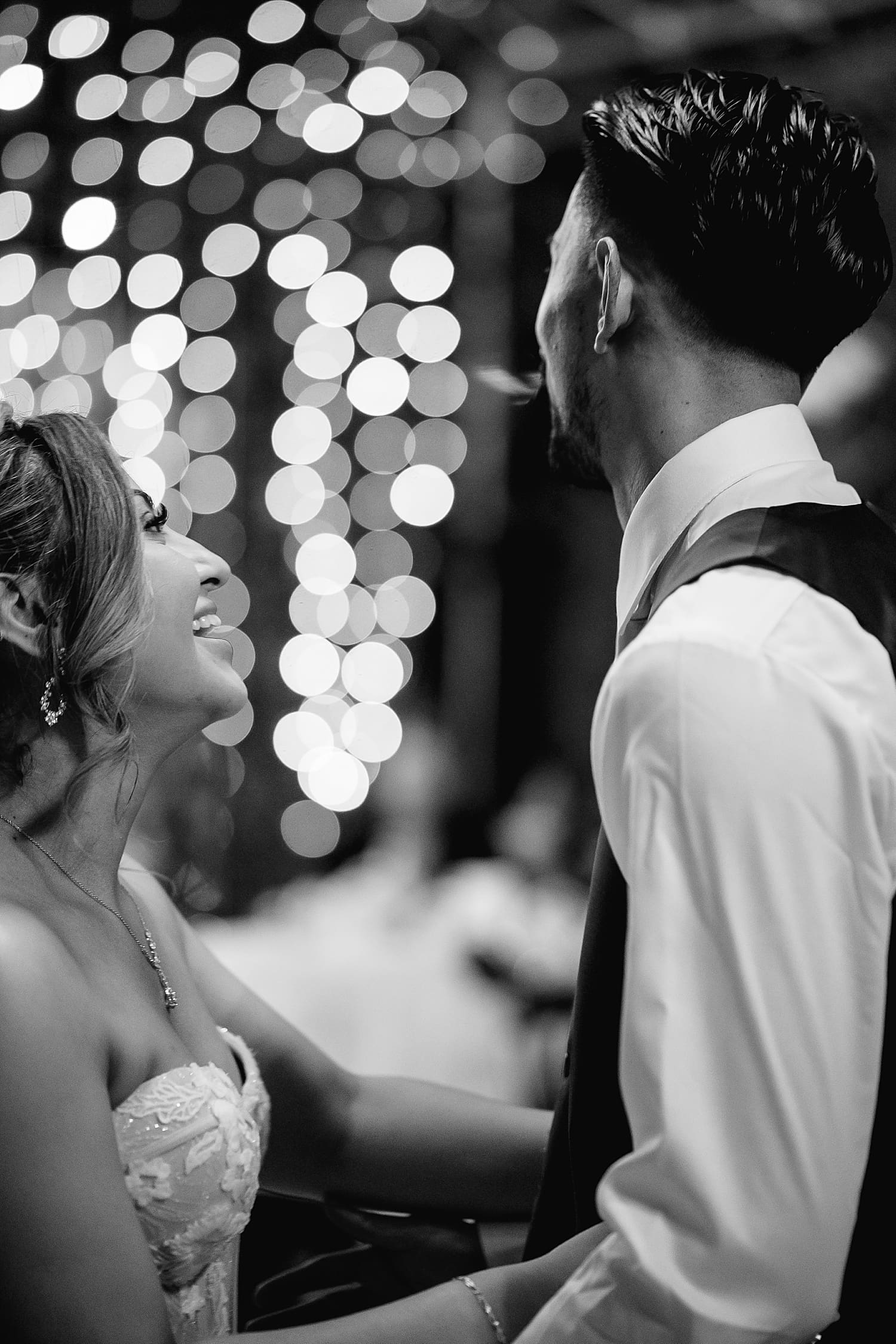 couple gaze at each other under twinkle lights by southern California wedding photographer