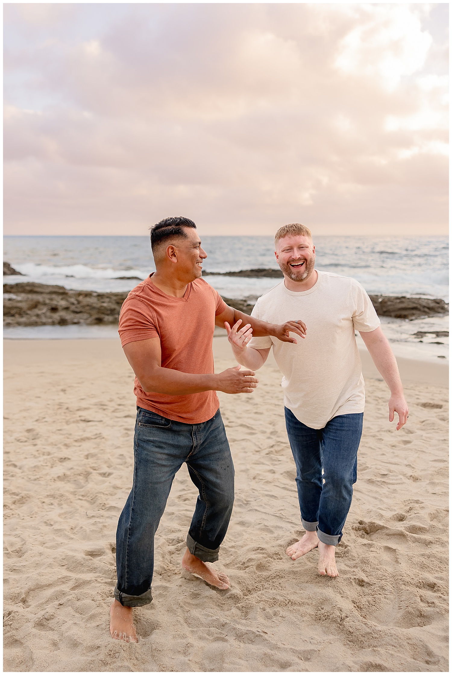 two men laugh together on the beach after learning how to prepare for your engagement session
