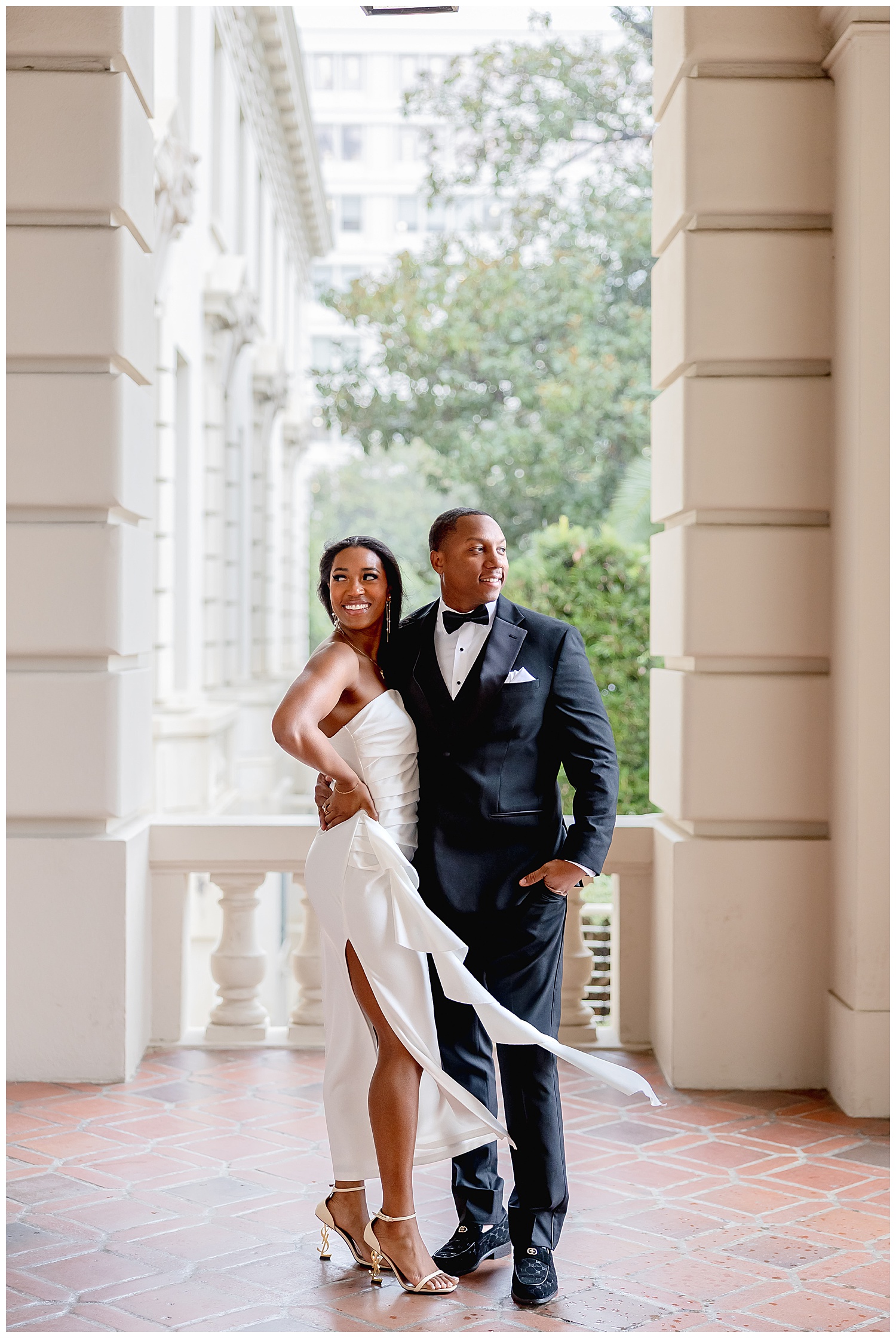 bride and groom stand on balcony after learning how to prepare for your engagement session