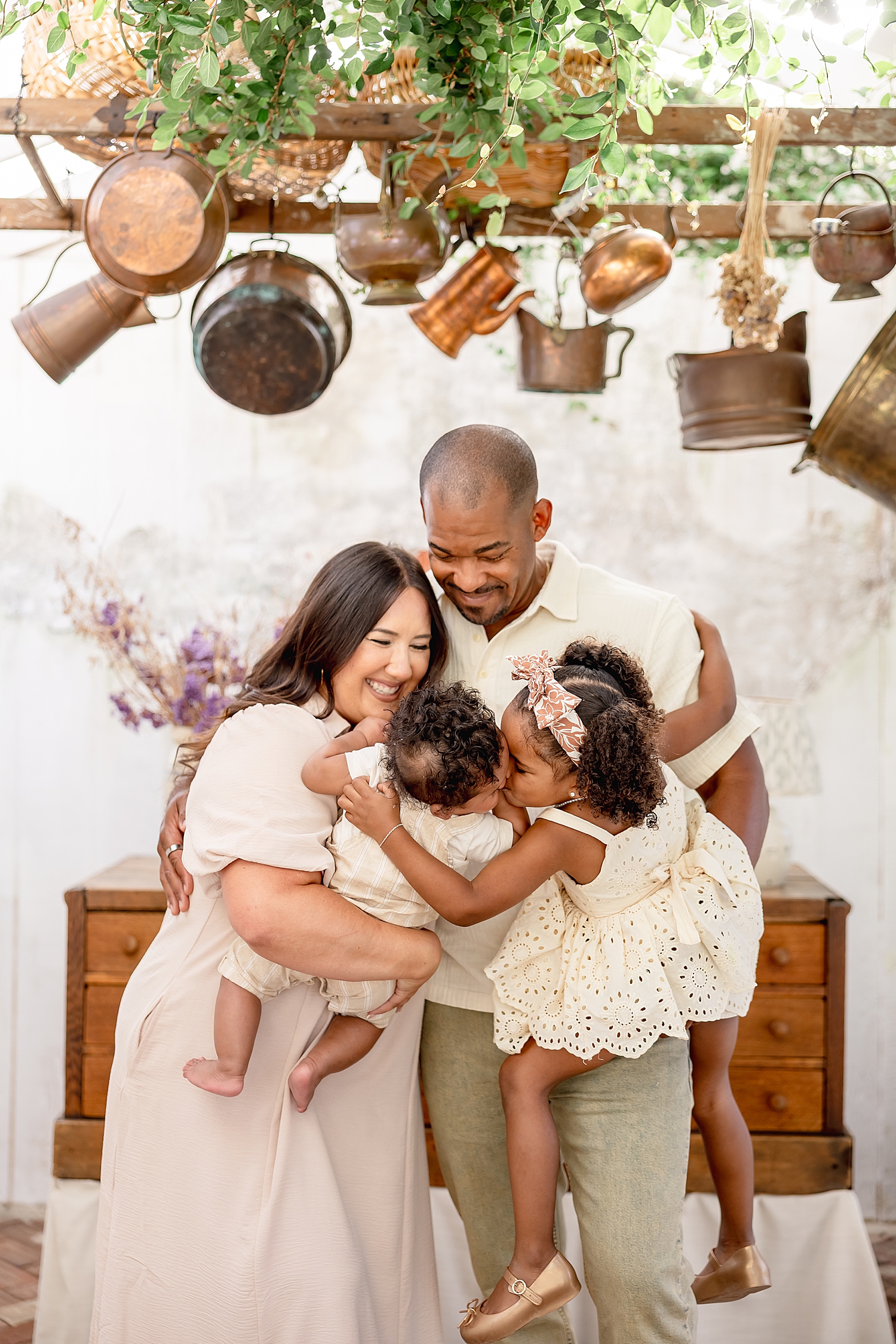 mom and dad snuggle their babies in stucco house for mini sessions