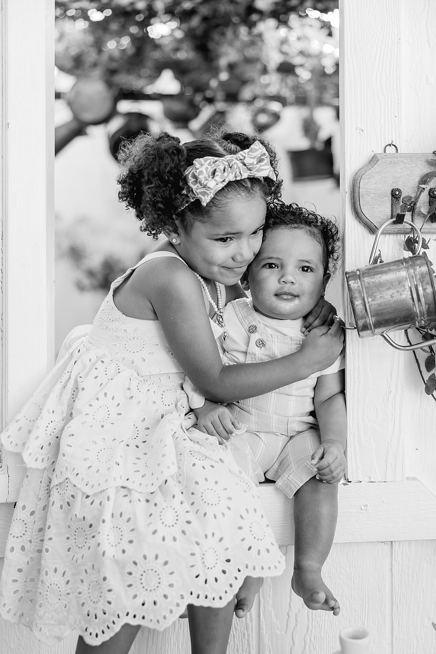 two toddlers sit in little window smiling together by Southern California photographer