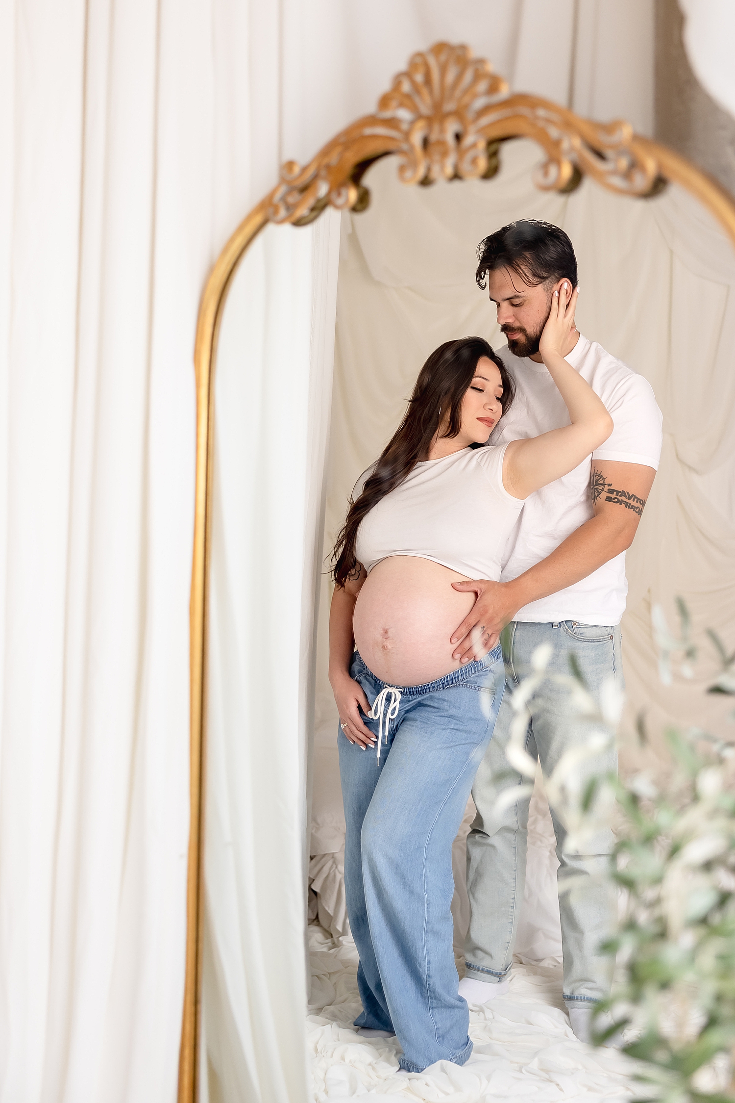 man stands behind his pregnant wife and holds her close by Southern California photographer