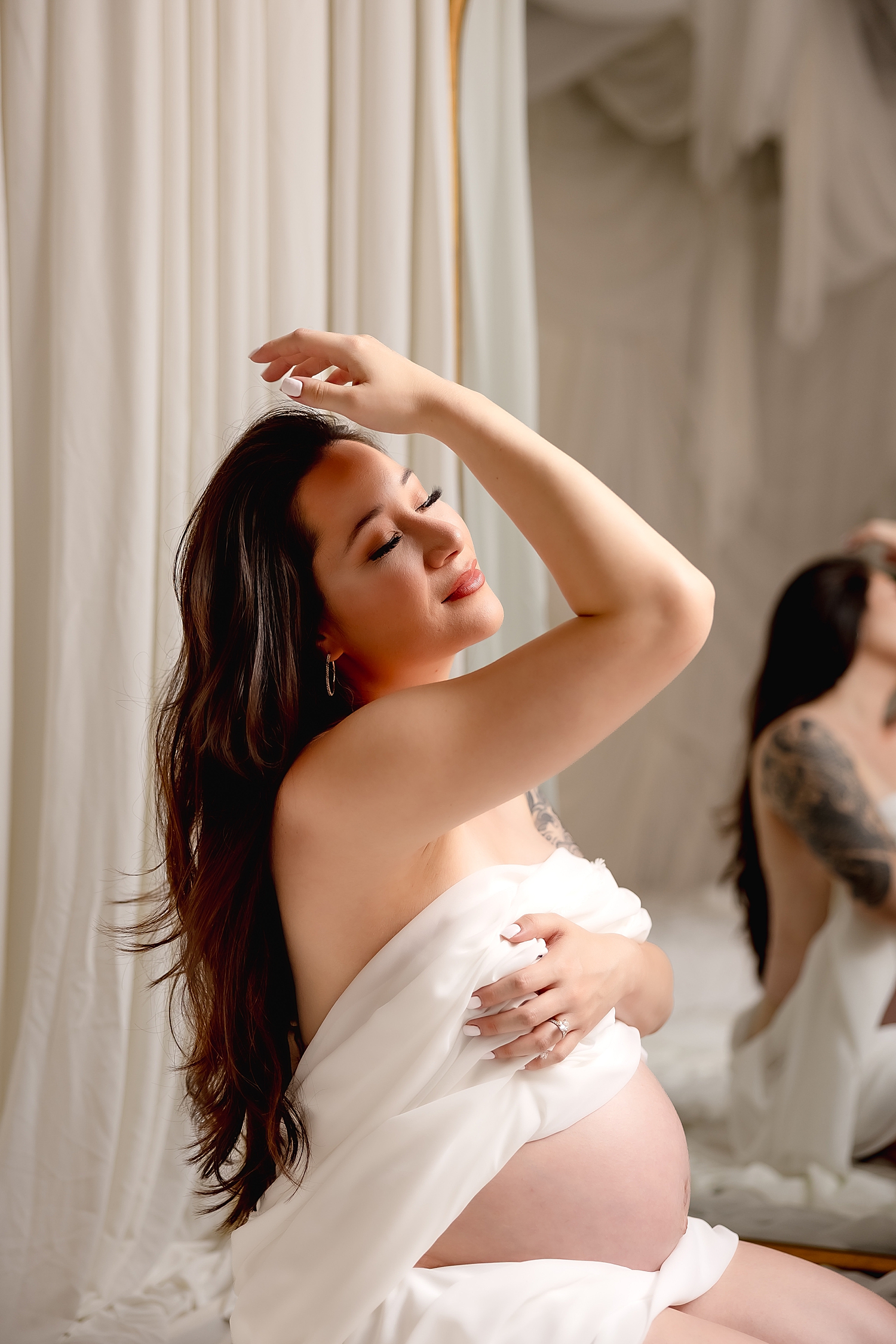 woman runs hand through hair in front of mirror by Southern California photographer